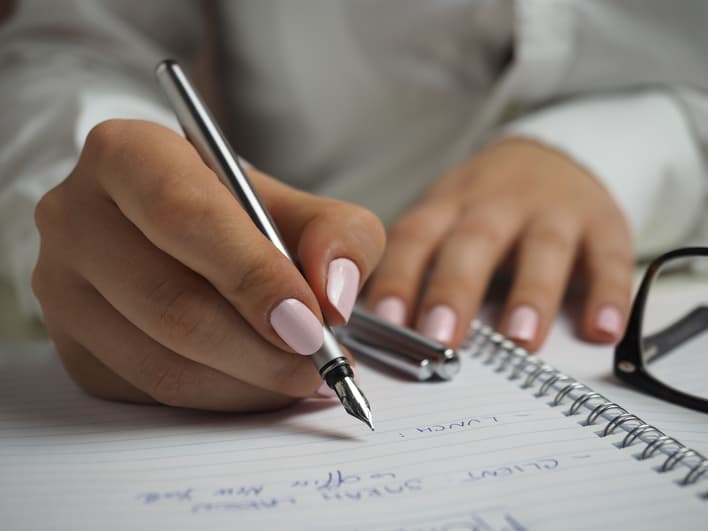 Eine Person schreibt mit einem Stift